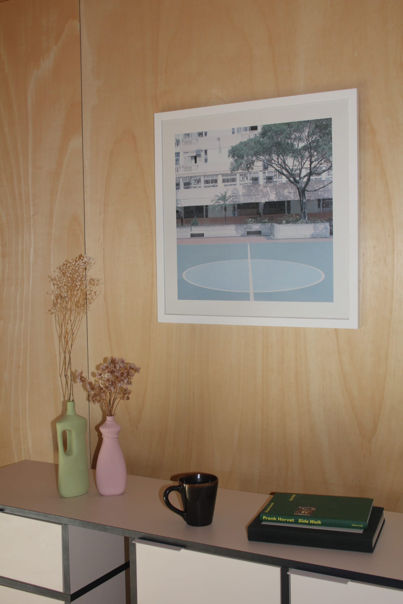 Photo of a wooden interior. A cup of coffee and books on a buffet.