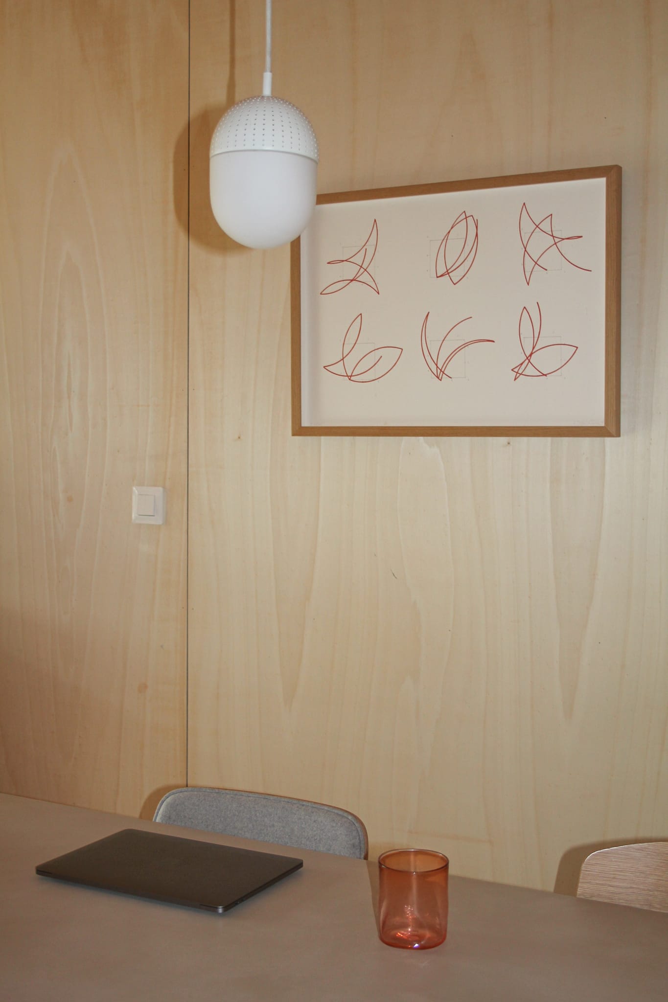 A computer and a glass on a table.